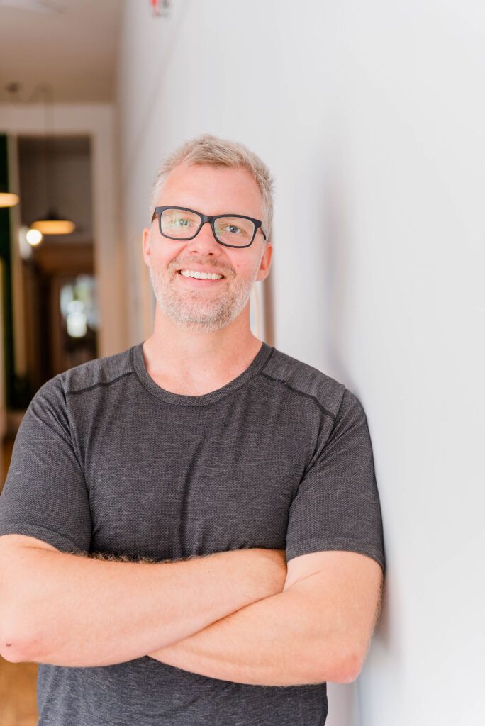 a man with glasses smiling